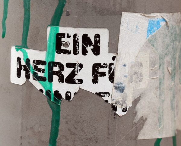 Angerissenes Papier auf einer Wand, zu lesen ist "ein Herz f...". Foto (Ausschnitt): Peter Weidemann, pfarrbriefservice.de