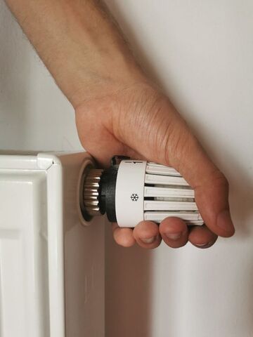 Eine Hand dreht an einem Radiator. Foto: Alexandra Koch, pixabay, pfarrbriefservice.de
